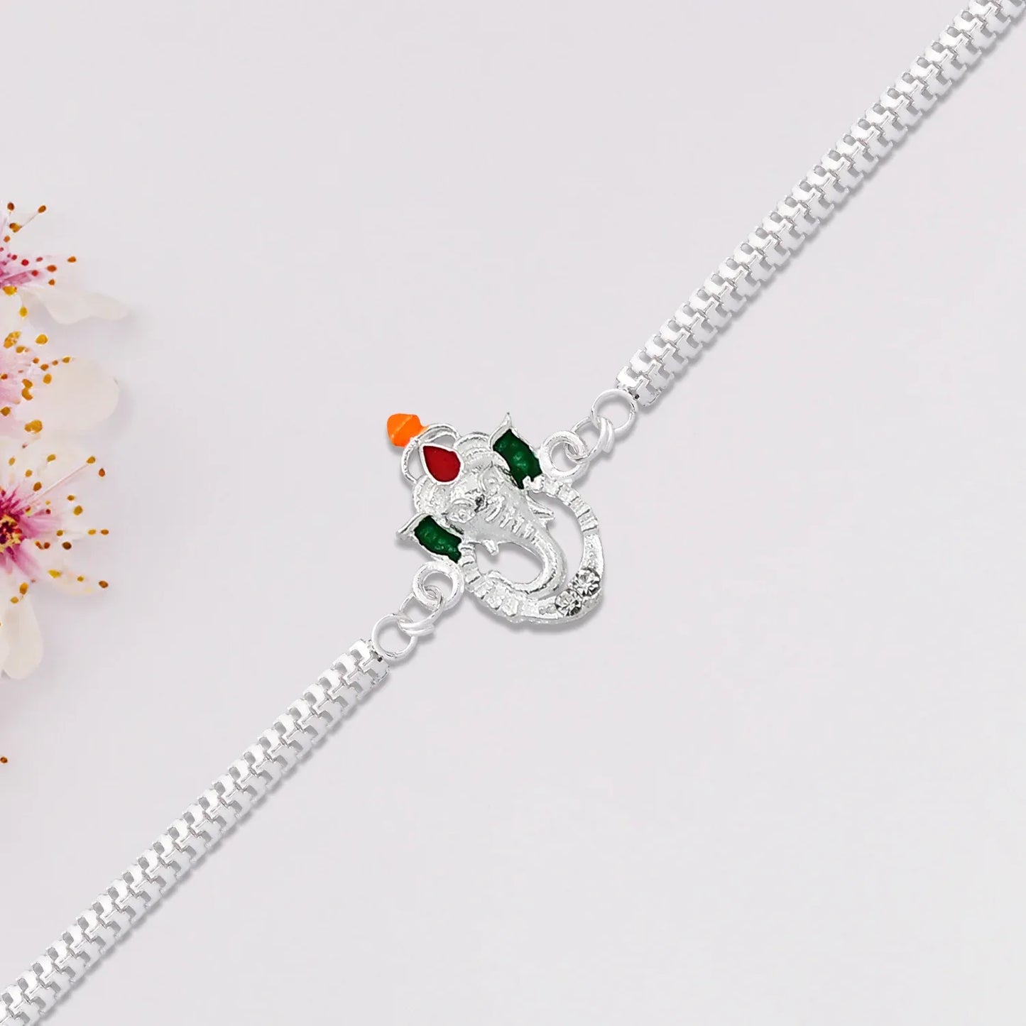 Stylish Ganesha Rakhi With Enamel Highlights And Silver Metal Chain - Zidbik
